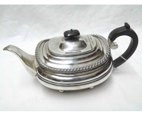 George V Tea Pot of slightly compressed oval form, with gadrooned rim, ebonised handle and finial, supported on four ball fee