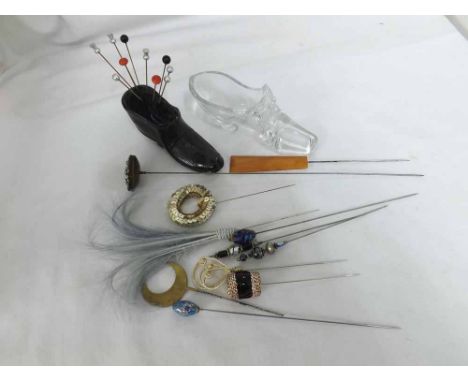 A box containing a Black Glass Shoe Ornament, formed as a pin cushion, clear glass shoe; together with a few other Hat Pins w