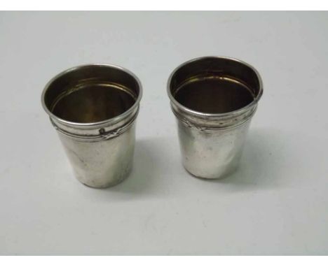 A pair of Continental white metal Tot Measures with reed and tie borders near the tops, 1 1/2" tall, 18gms total (2) 