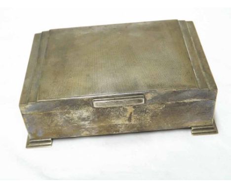 George VI encased Cigarette Box of shaped rectangular design in Art Deco taste, engine turned lid, stepped bracket feet, 7 1/