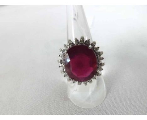 A high grade precious metal Ring set with a large centre Oval Ruby, the ruby measuring 15mm x 12mm, with small Brilliant Cut 