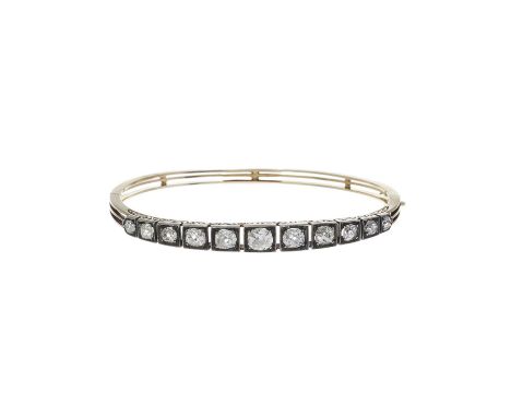 A late Victorian gold and silver, graduated old-cut diamond hinged bangle bracelet, with scrolling engraved sides, estimated 