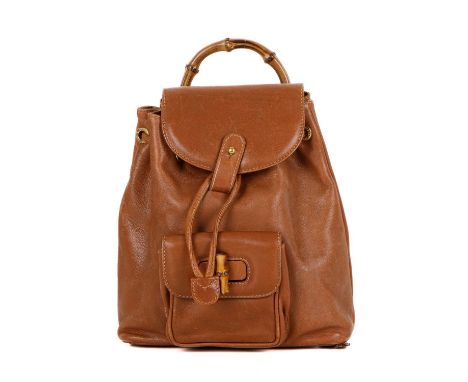 Gucci, a small Bamboo backpack, featuring a smooth tan leather exterior, curved bamboo top handle, front patch pocket with ba
