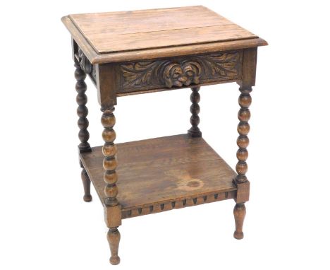 A late 19th/early 20thC oak side table, the rectangular top with a moulded edge above a carved frieze drawer, on bobbin turne