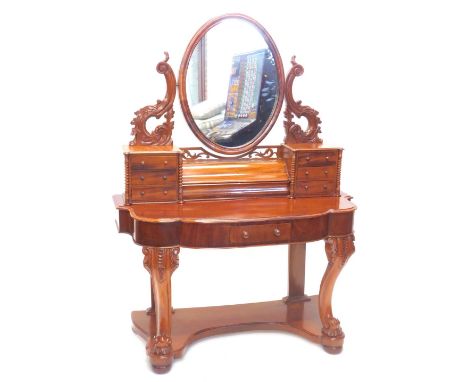 A Victorian walnut Duchess style dressing table, the oval mirror with shaped carved supports above two banks of three trinket