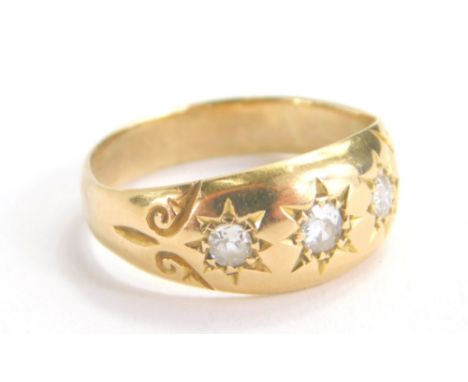 A gold ring, set with three diamonds in a textured shank, size K, 3.1g.