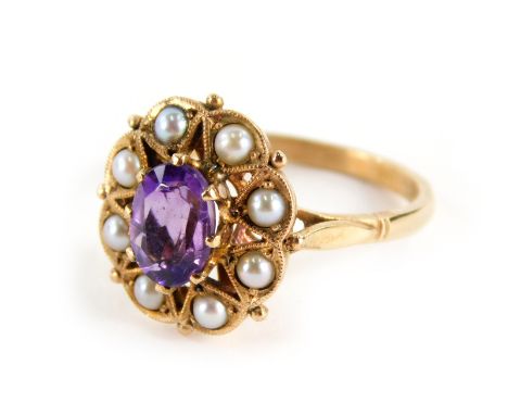 An early 20thC 9ct gold ladies amethyst and pearl ring, the oval claw set purple stone, surrounded by small pearls, on a part