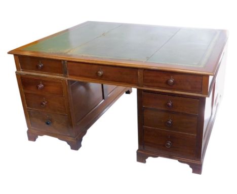 A mahogany pedestal partner's desk, the rectangular top with a green leather inset and a moulded edge, above an arrangement o