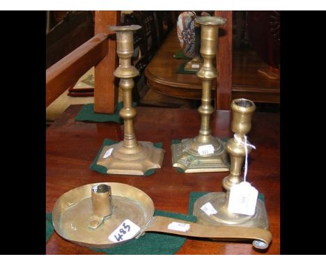 Three brass 18th century candlesticks, together with a drip pan brass candlestick 