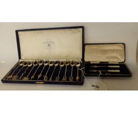 A lot comprising a cased set of twelve white metal coffee spoons and a cased pair of silver and mother of pearl pickle forks,