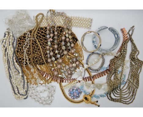 A bag full of vintage costume jewellery to include a beaded skull cap, a carved lucite bangle and a snake necklace Condition 