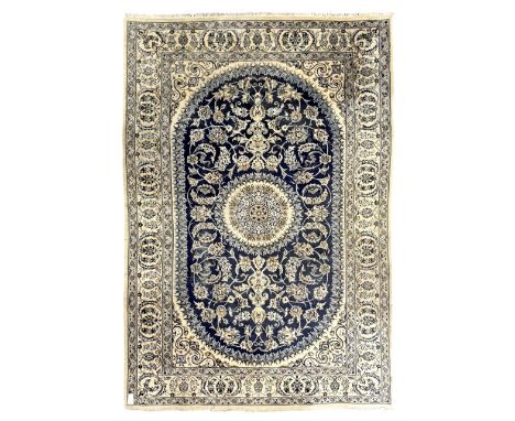 Persian Kashan ivory and indigo ground rug, traditional and intricate design around a central medallion, in tones of cream an