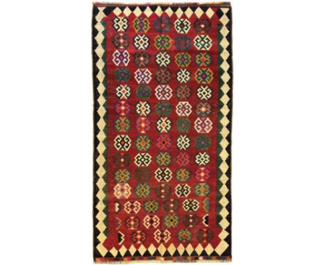 Southwest Persian Qashqai Kilim red ground rug, the central field adorned with rows of multicolored hexagonal medallions with