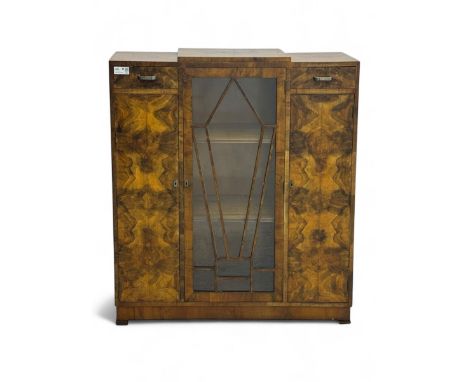 Art Deco burr walnut drinks cabinet, geometric central glazed astragal door enclosing two fixed shelves, flanked by symmetric