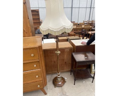 A MID 20TH CENTURY STANDARD LAMP WITH TURNED COLUMN HAVING GILT FOLIATE DECORATION ON BRASS LION PAW FEET 