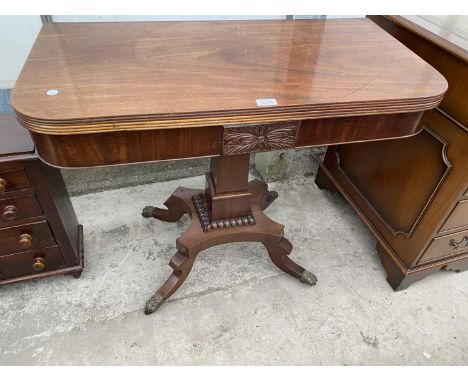 A 19TH CENTURY MAHOGANY FOLD-OVER CARD TABLE ON QUATREFOIL BASE WITH BRASS LION PAW FEET, 35" WIDE 