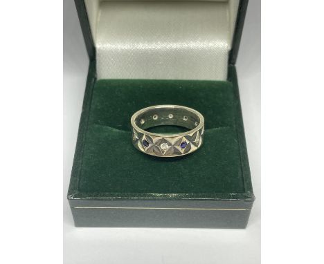 A BAND RING WITH BLUE AND CLEAR STONES MARKED 9CT AND SIL IN A PRESENTATION BOX 