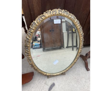 AN ORNATE OVAL GILT FRAMED MIRROR 