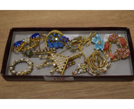 A small selection of brooches and stick pins, including enamelled pieces, paste set examples and a faux pearl circular brooch