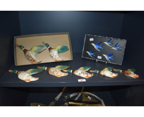 A set of seven early 20th century Keele Street pottery graduated flying duck plaques, hand painted on a glazed ground, larges