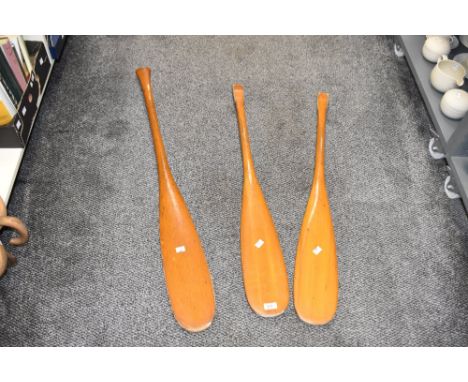 Three vintage pine canoe coracle paddles, longest 107cm.