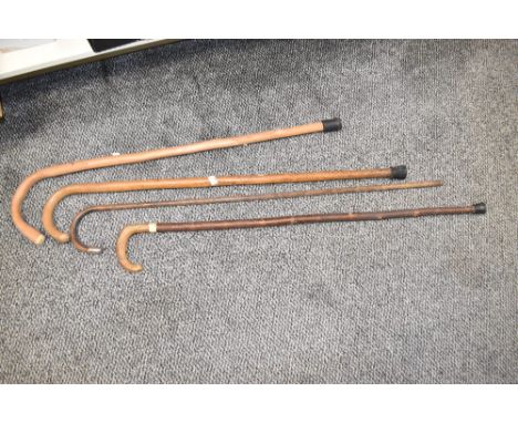 Four late 19th / early 20th century wooden walking sticks, to include a bamboo silver mounted stick, impressed marks for Vaug