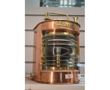 An early 20th century Heklicht copper and brass ships port lantern, having a bow-fronted form with fresnel lens glass, h30cm.