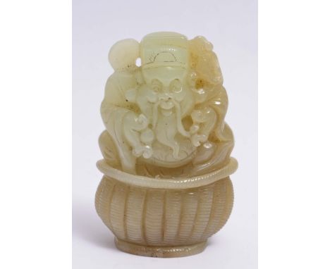 A CHINESE CELADON JADE FIGURE OF JUROJIN seated upon a basket and holding fruits, 19th Century, 6.2cm high