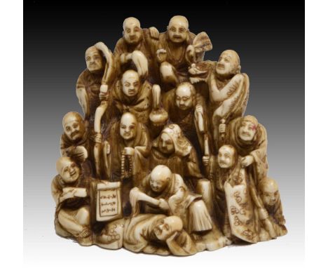 A JAPANESE IVORY NETSUKE CARVED AS EIGHTEEN RAKAN in a group forming a pyramid, signed Kumoyama?, late 19th Century