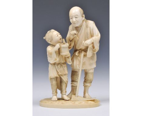 A JAPANESE IVORY OKIMONO of a farmer with hoe standing talking to his son who holds a concertina paper lantern, signed Shugyo