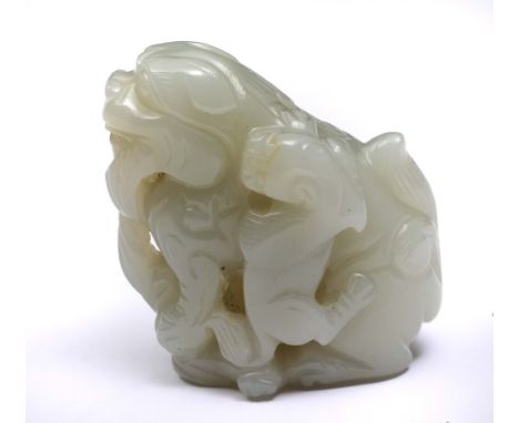 A CHINESE WHITE JADE GROUP OF DOG OF FO and cub, the former holding a tassel in its mouth, the ball under its right paw, 19th