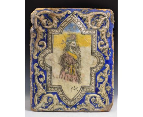 A LARGE QAJAR TILE with Persian profile figure within a raised blue border, inscribed, 19th Century, 42cm x 32cm