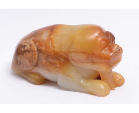 A CHINESE MOTTLED BROWN AND GREYISH WHITE JADE RECUMBENT ORNITHOLOGICAL BEAST facing forward with scrollwork around the front