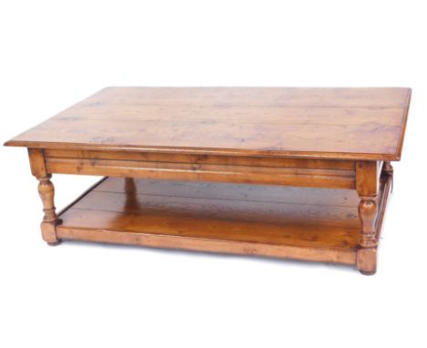 A varnished oak coffee table, with three planked top and single shelf base on column supports, 47cm high, 151cm wide, 90cm de