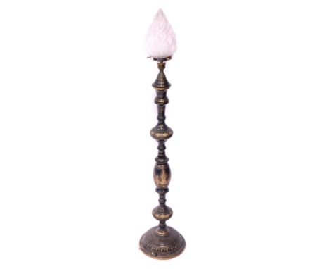 An Eastern inspired blackened metal table lamp, with engraved silver detail, and a glass flame shade, 106cm high.