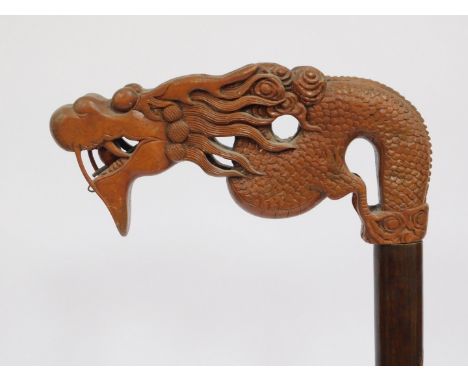 An oriental carved standard lamp, the arch top with dragon face, on a building and tree engraved stem, on a stepped foot, 176