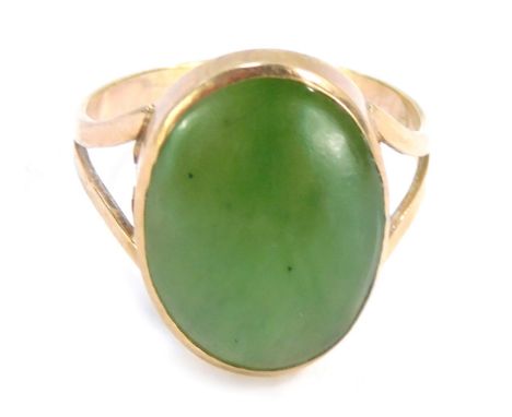 A jade dress ring, the oval jade in rub over setting a v splayed shoulders on a yellow metal band stamped 9ct, ring size Q, 3