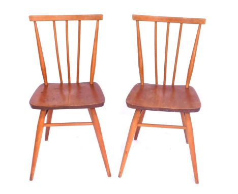 A pair of Ercol beech stick back kitchen chairs, each with registered design no 884923.