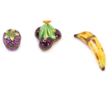 Three novelty fruit ceramic Limoges trinket boxes, comprising banana, 8cm wide, a group of three cherries, 4.5cm wide, and a 