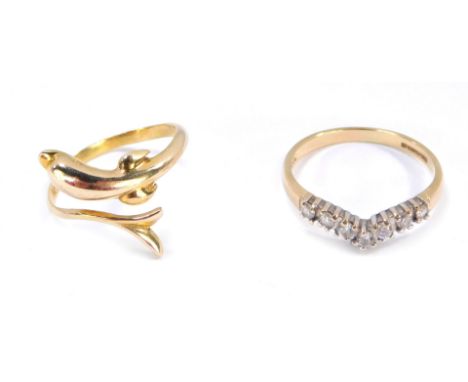 Two dress rings, comprising a dolphin twist ring, yellow metal stamped 585, ring size K, and a 9ct gold wishbone ring set wit