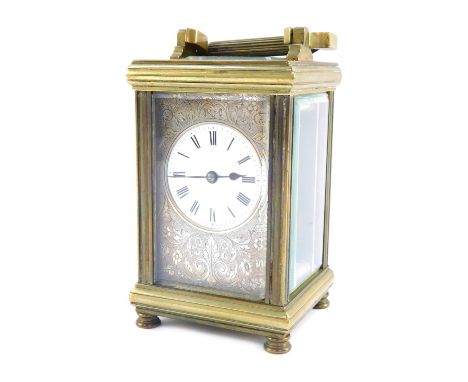 An early 20thC French brass carriage timepiece, with silvered floral scroll face, white enamel Roman numeric dial, mark to re