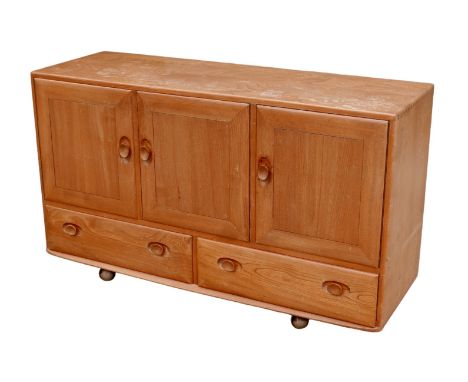 An Ercol elm sideboard, model 468, a double door and a single cupboard above, each enclosing an adjustable shelf, above two l