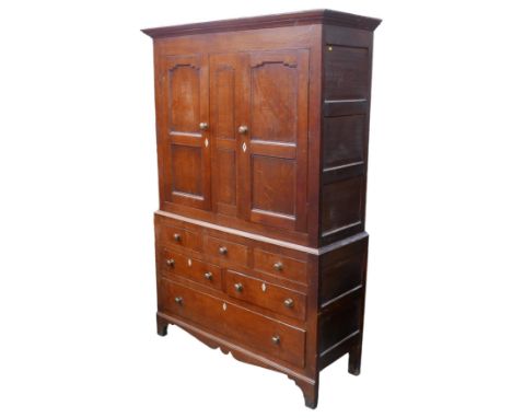 A 19th century oak over pine cupboard, upper section with two panelled doors opening to reveal a hanging space, the lower sec