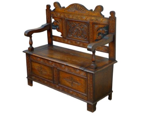 An Edwardian carved oak monk's bench, with lift lid storage in seat, 106.5 by 42.5 by 105cm high. 