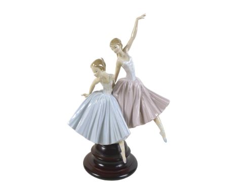 A large Lladro figurine 'Merry Ballet', modelled as two ballerinas, raised on a circular wooden plinth, #5035, 48.5cm high. 