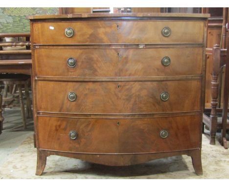 A Regency mahogany bow front bedroom chest of four long graduated drawers with well matched flame veneers over a shaped apron