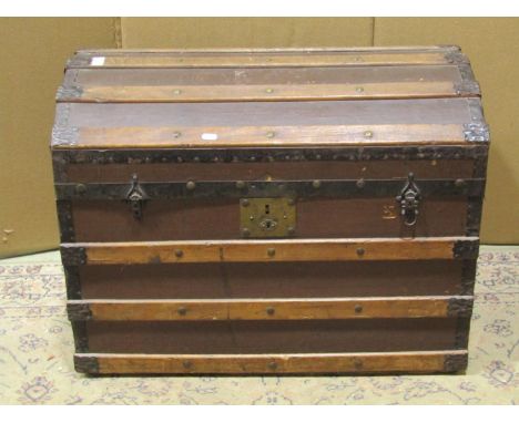 An antique timber lathe bound domed top trunk with hinged lid containing a collection of woollen blankets 