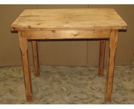 A small vintage stripped pine kitchen table of rectangular form  with rounded corners over an end frieze drawer raised on squ