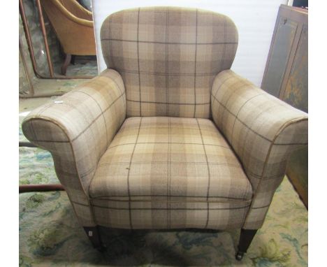 An Edwardian easy chair with rolled arms and tartan style upholstery in light brown tones raised on square tapered forelegs w
