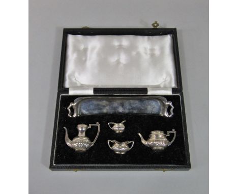 A good quality cased five piece miniature silver half fluted tea service, comprising tea pot, water pot, milk jug, sucrier an